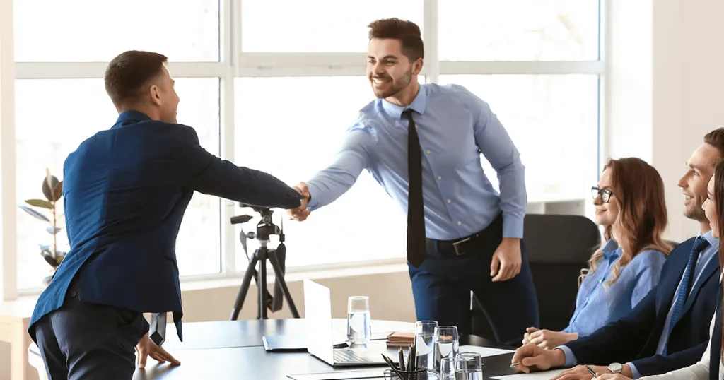 A man shaking hands with another man, after having a productive meeting.