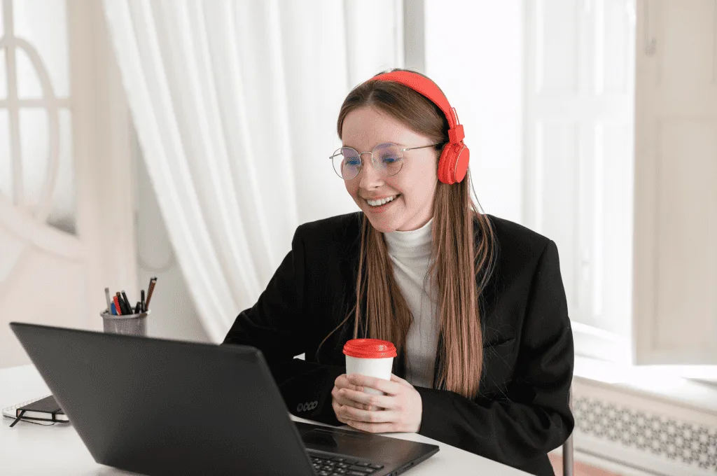 a woman smiling while holding a cup of coffee
