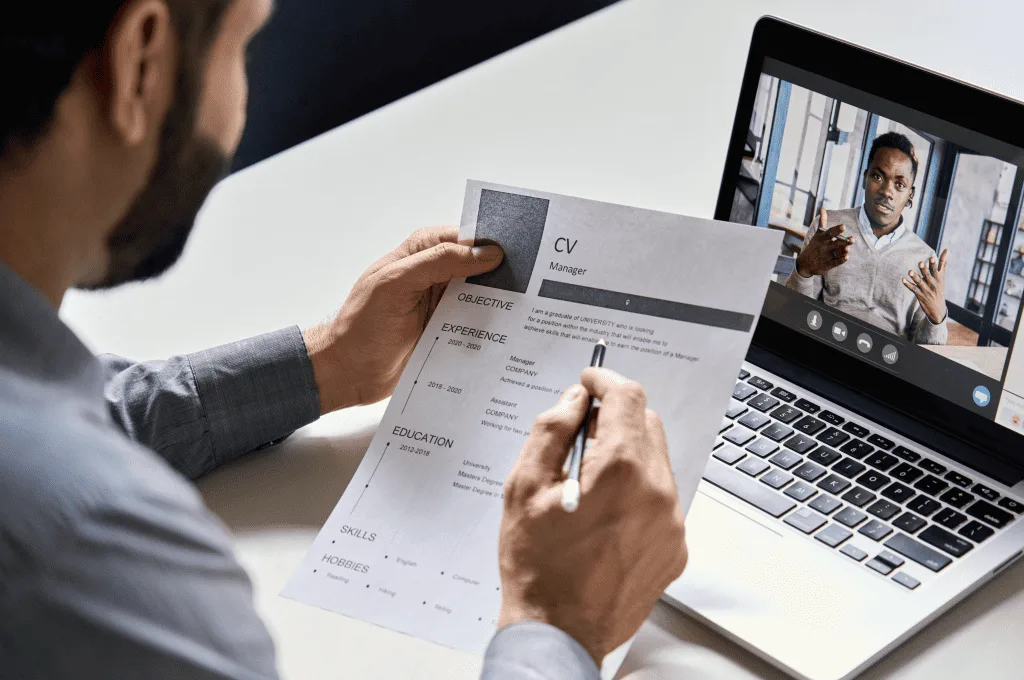 An employer reading CV during a virtual job interview with a candidate