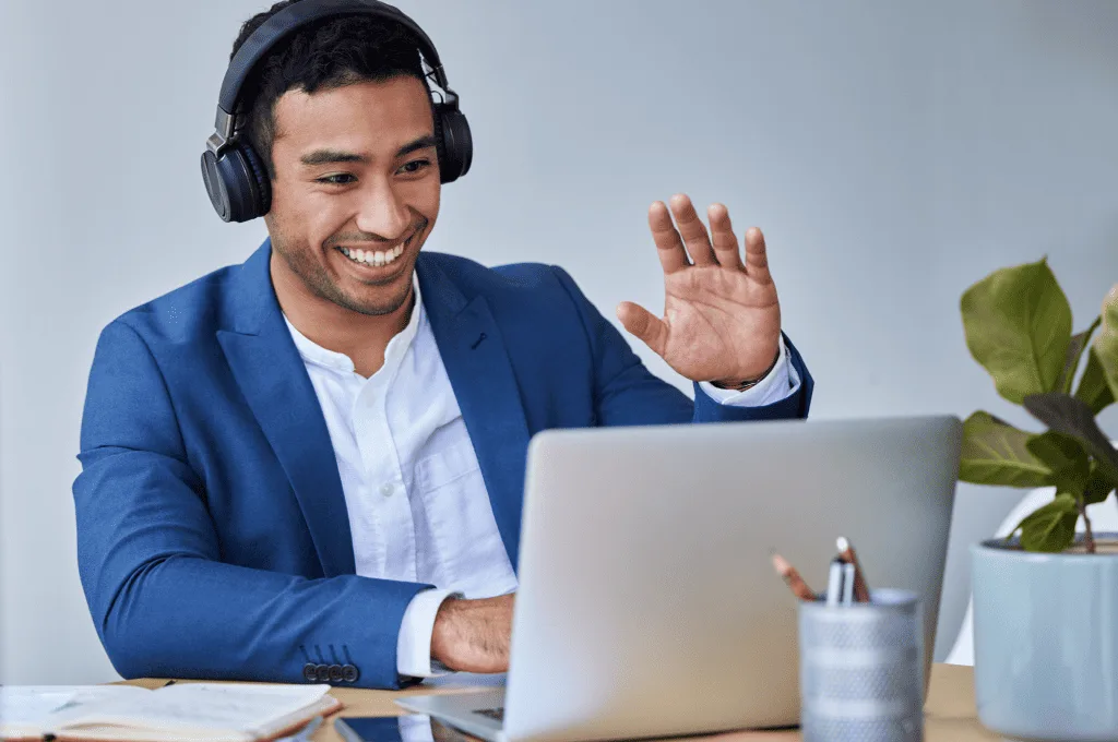 An individual waving at the computer screen
