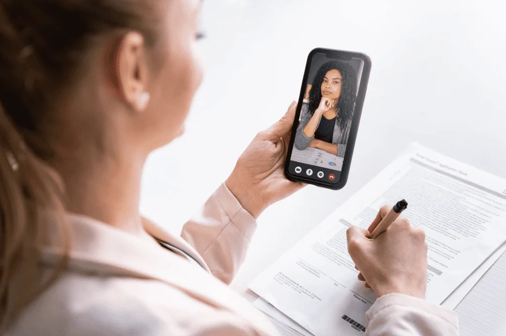 Close up of a woman holding smartphone during an online video call