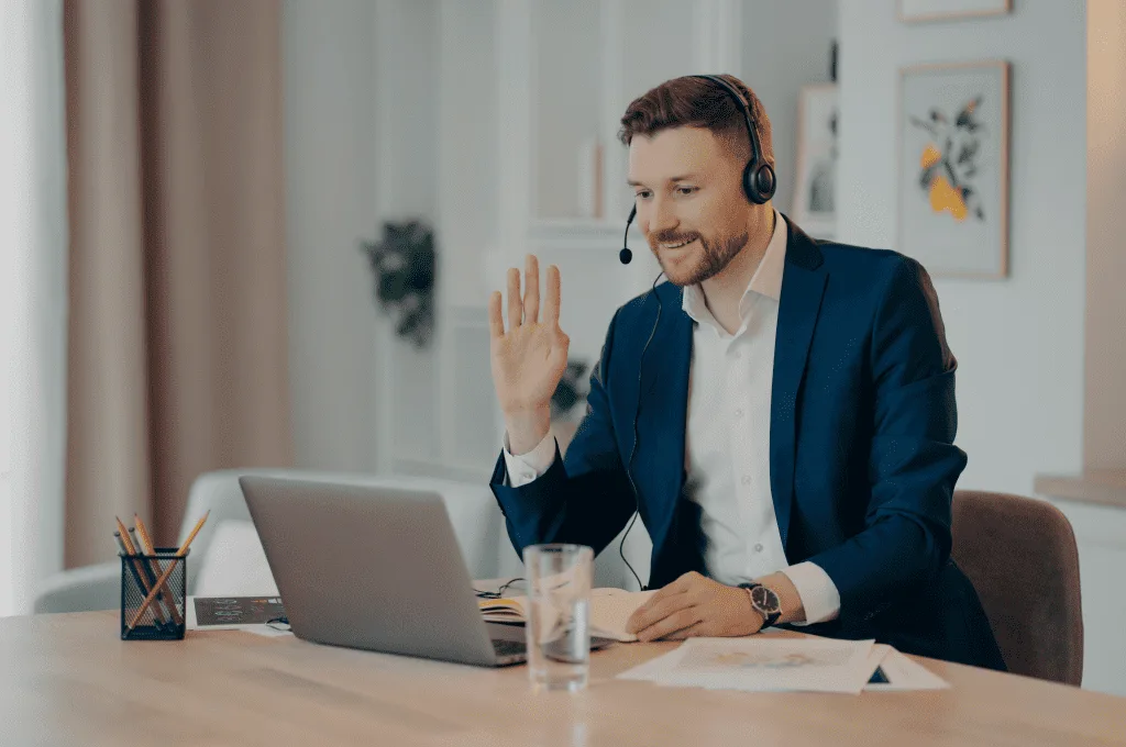 Smiling Young Professional Waving During an Online Meeting