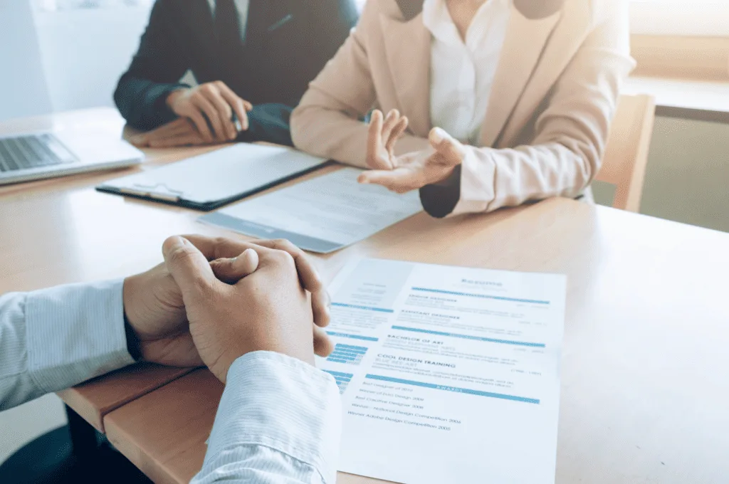 business job interview where a person is sitting in front of managers with their resume