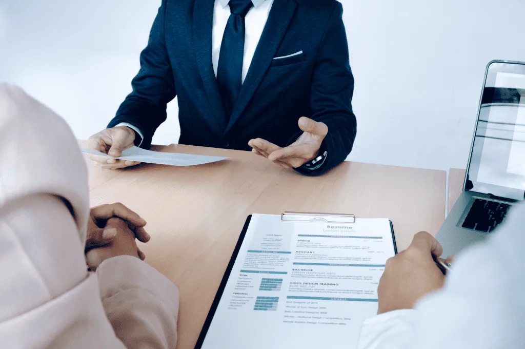 business situation where job interview is conducted as the job seeker is present with the resume in front of the managers