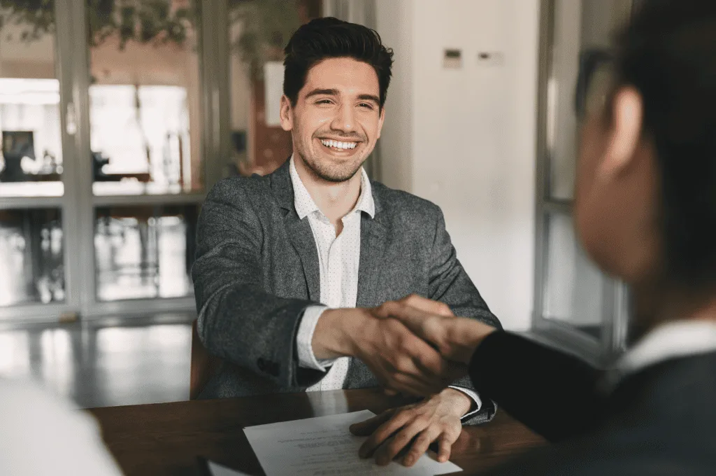Happy individual rejoicing shaking hands with employee when recruited during interview