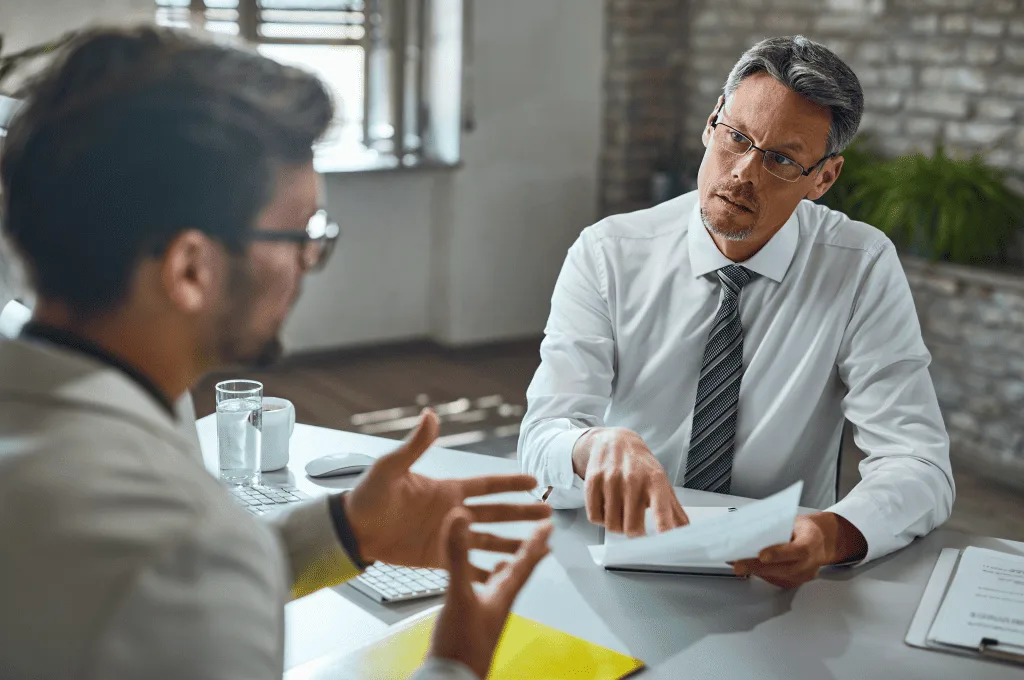 member-of-human-resource-team-talking-with-candidate-while-reviewing-his-resume-during-job-during-an-interview.